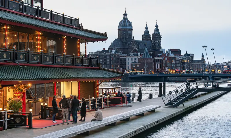Ingang van Sea Palace bij avond, met zicht op de Sint-Nicolaasbasiliek
